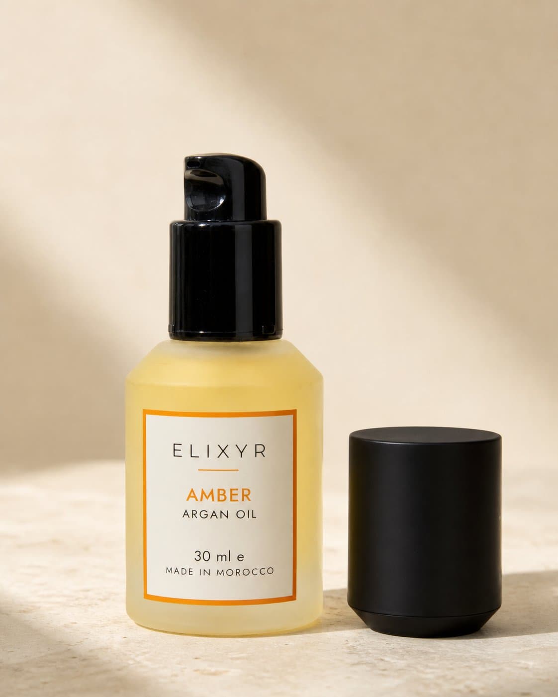 The Amber bottle with its pump revealed, cap standing beside