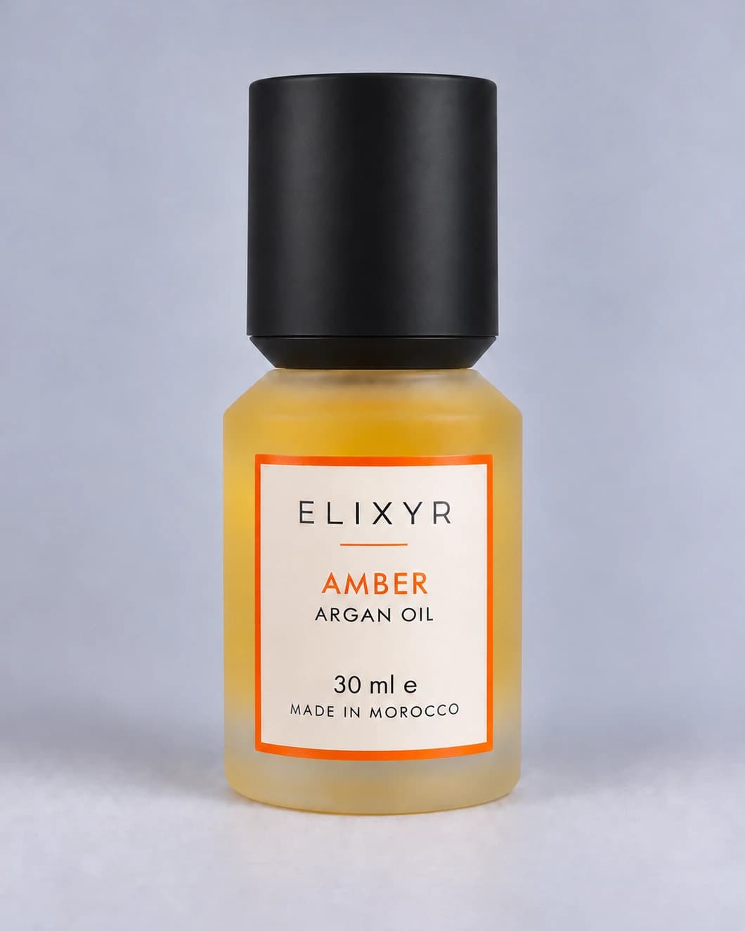 ELIXYR Amber 30ml fragranced argan oil in frosted glass, with its matte black cap on