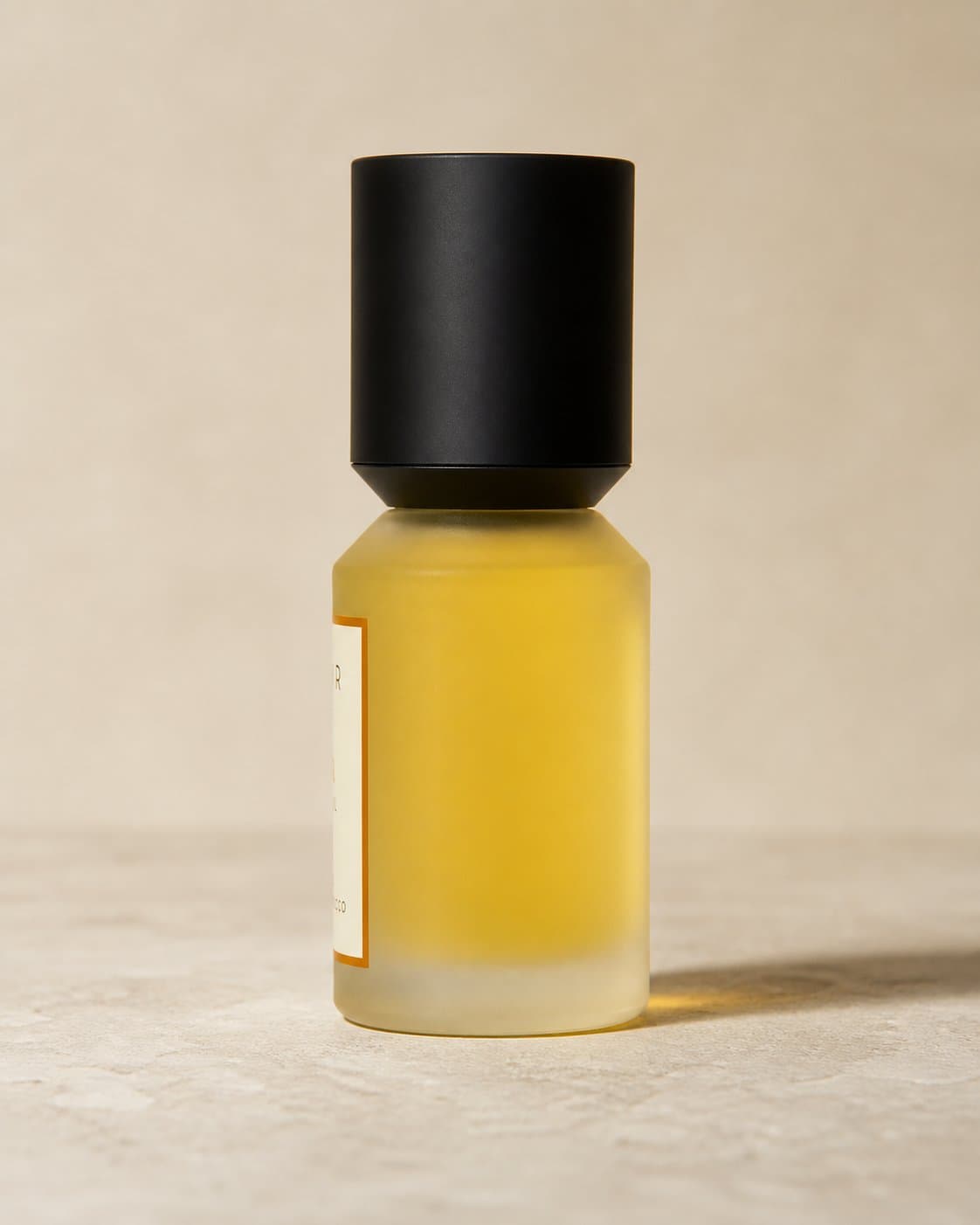 The ELIXYR bottle: frosted glass, black pump beneath a separate matte black cap, 30ml