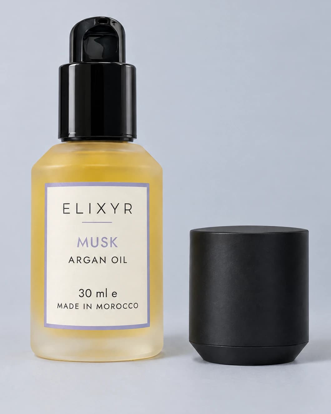 ELIXYR Musk 30ml fragranced argan oil in frosted glass, glossy black pump exposed with the matte black cap beside it